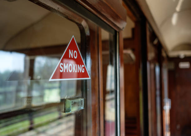 triangle de présignalisation no smoking classique vu attaché à un panneau de verre à un millésime, compartiment de train de première classe. - tobacco wagon photos et images de collection