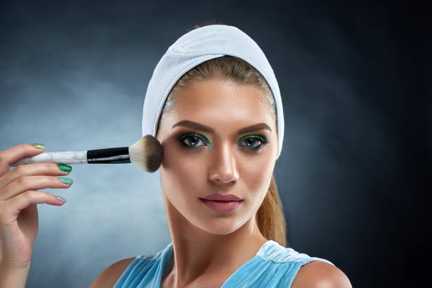 istock Gorgeous girl drawing blush for herself and posing at camera. 849137700