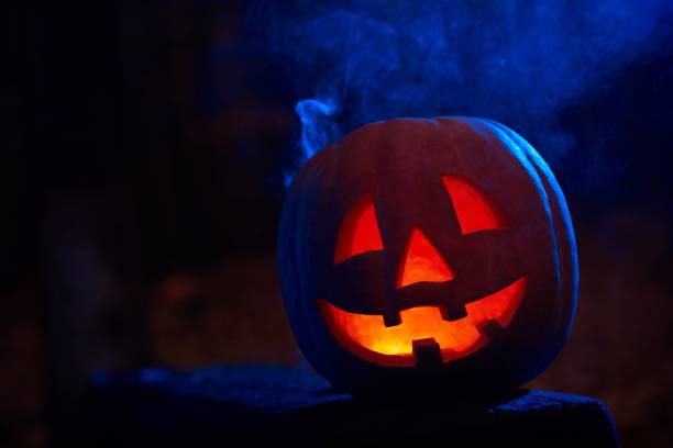 istock Scary pumpkin decorated for Halloween with fire and smoke inside. 849140646