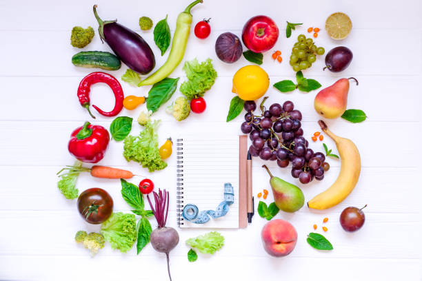 istock Healthy food, diet eating, detox background - different fruits and vegetable, empty open notebook, and measuring tape on white wooden table. Top view. Selective focus. 849147190