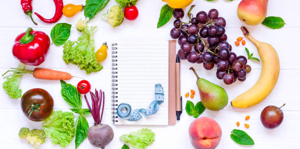 istock Healthy food, diet eating, detox background - different fruits and vegetable, empty open notebook, and measuring tape on white wooden table. Top view. Selective focus, wide photo 849147220