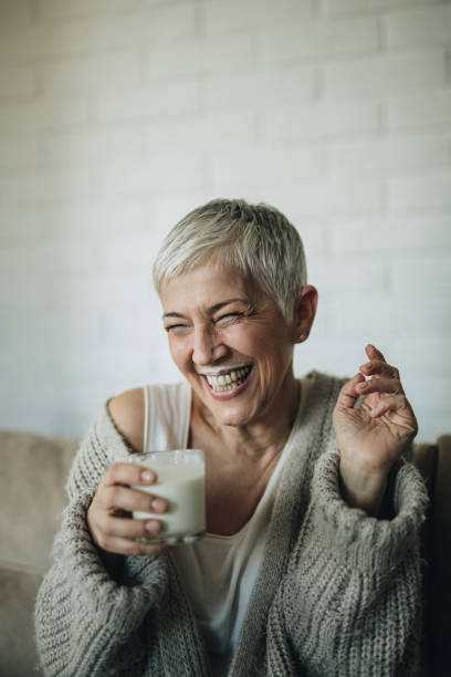 istock Cheerful mature woman having fun while drinking milk. 849151982