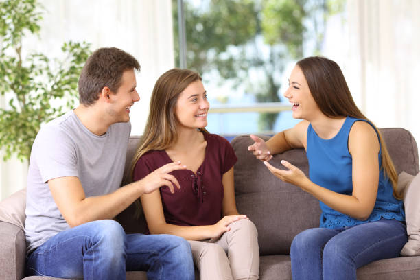 istock Three joyful friends talking on a couch at home 849152318