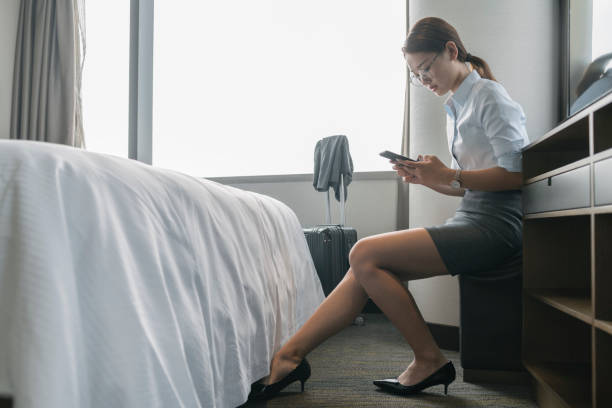 istock woman sitting in hotel room using smartphone 849157798