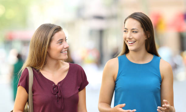istock Two friends walking and talking on the street 849158128