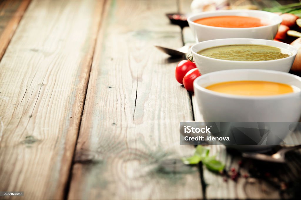 Varietà di zuppe di crema su vecchio sfondo di legno - Foto stock royalty-free di Zuppa