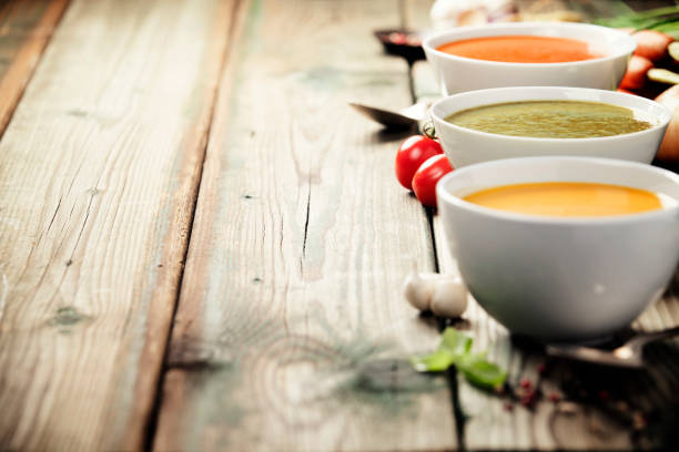 Variety of cream soups over old wood background stock photo