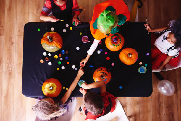 istock Kids in costume decorating a pumpkin 849165778