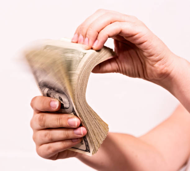 istock Hand riffling thick bundle of American banknotes 849167468