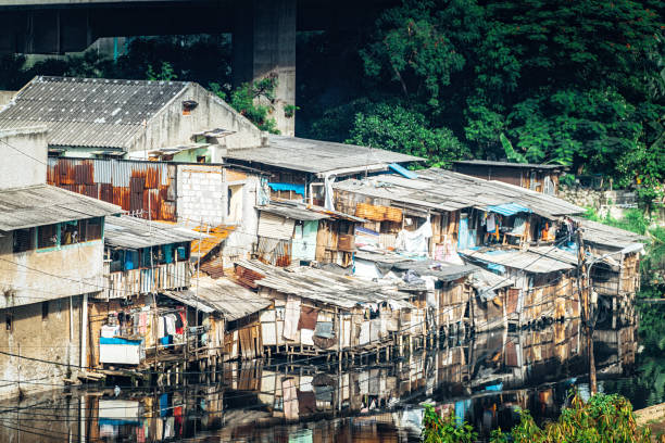 Slum Area in Jakarta, Indonesia Slum Area near polluted river under a bridge. Many people in Jakarta lives in slum areas, poverty is one of biggest problems in Jakarta city jakarta slums stock pictures, royalty-free photos & images