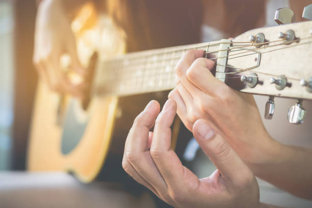 Men's hands are teaching women to play guitar.This image is blurred and Soft focus. stock photo