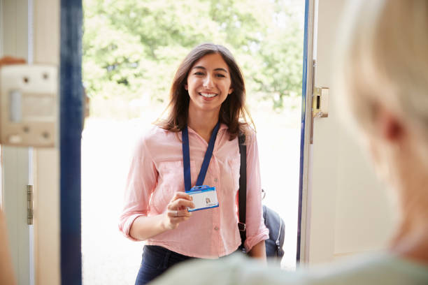Female care worker on home visit showing her ID, close up