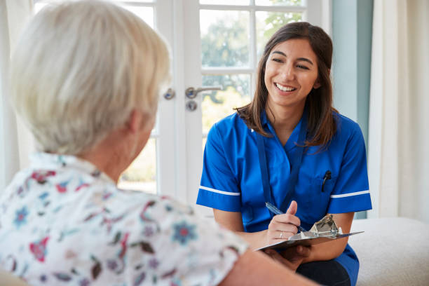 istock Senior woman sitting at home with care nurse taking notes 849181544