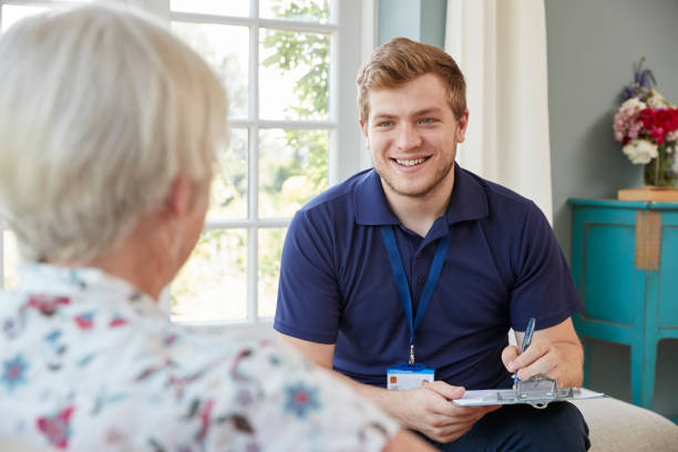 istock Senior woman at home with male care worker making notes 849181558
