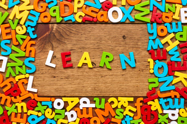 istock Overhead view of learn surrounded with colorful alphabets on wood 849181766