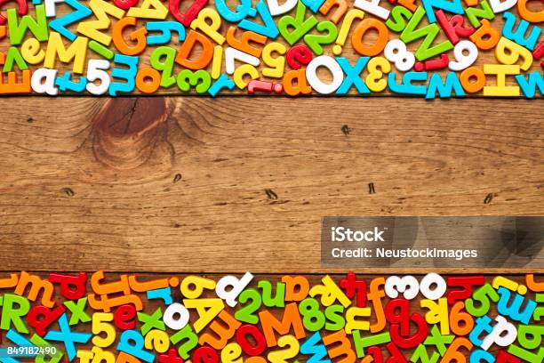 Overhead View Of Colorful Alphabets And Numbers Arranged On Wood Stock Photo - Download Image Now