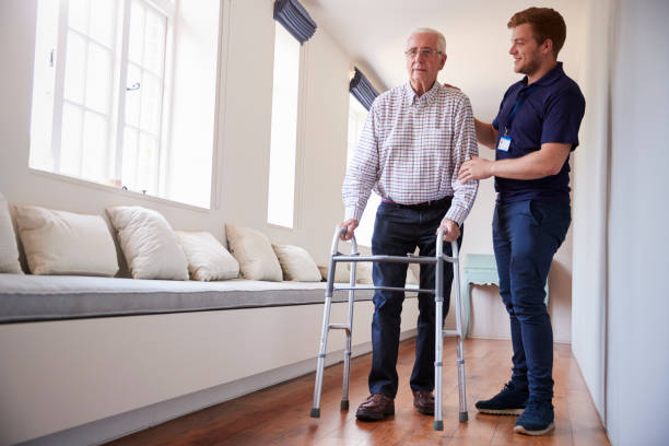 istock Senior woman using a walking frame with male nurse at home 849182556