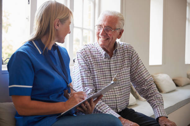 istock Senior man sits with nurse making notes at retirement home 849182608