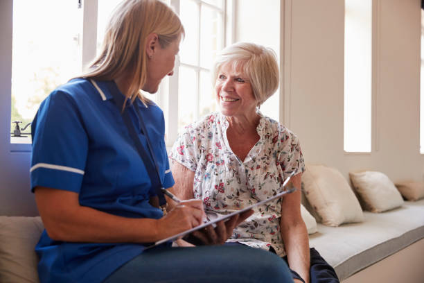 istock Senior woman sits with nurse making notes at retirement home 849182636