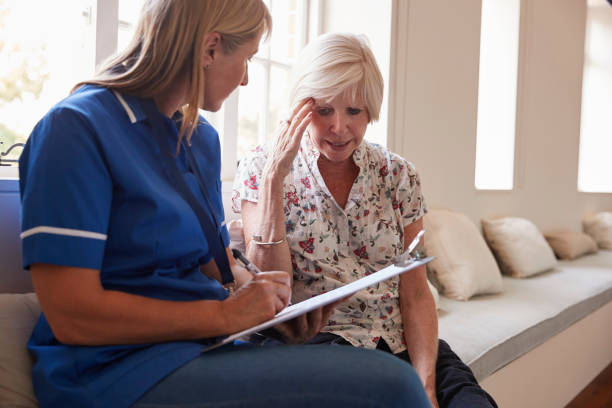 istock Senior woman sits with nurse making notes at retirement home 849182702
