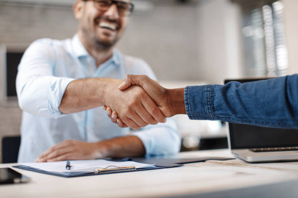 Close up of handshake in the office stock photo