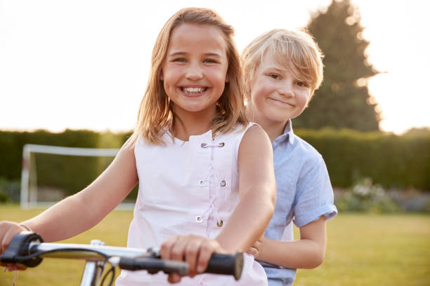 istock Two children riding a bicycle in the garden 849189070