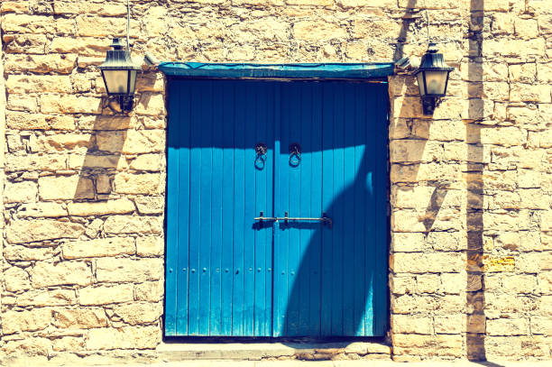 Ancient brick wall and blue wooden door. Limassol, Cyprus.