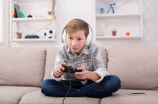 istock Excited teenage boy playing video game at home 849192510