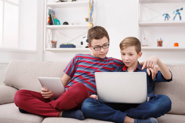 istock Two teenage boys using tablet on couch at home 849192702