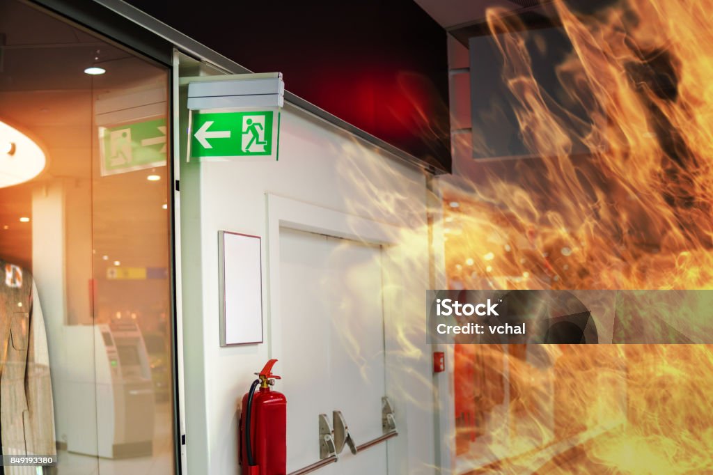 Emergency fire exit sign and fire in shopping mall. Fire - Natural Phenomenon Stock Photo