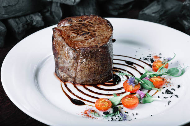 istock Tenderloin steak on plate with salad on dark background 849196534