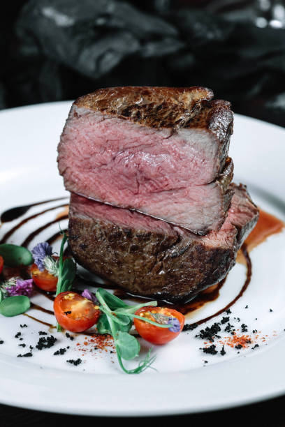 istock Tenderloin steak on plate with salad on dark background 849196700