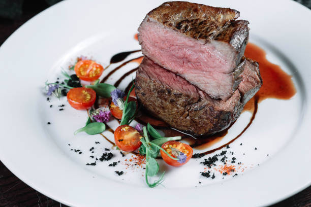 istock Tenderloin steak on plate with salad on dark background 849196814