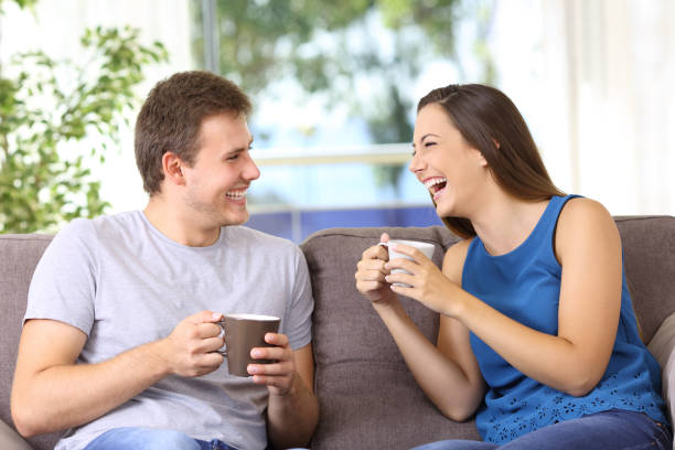istock Two people talking and laughing at home 849197350