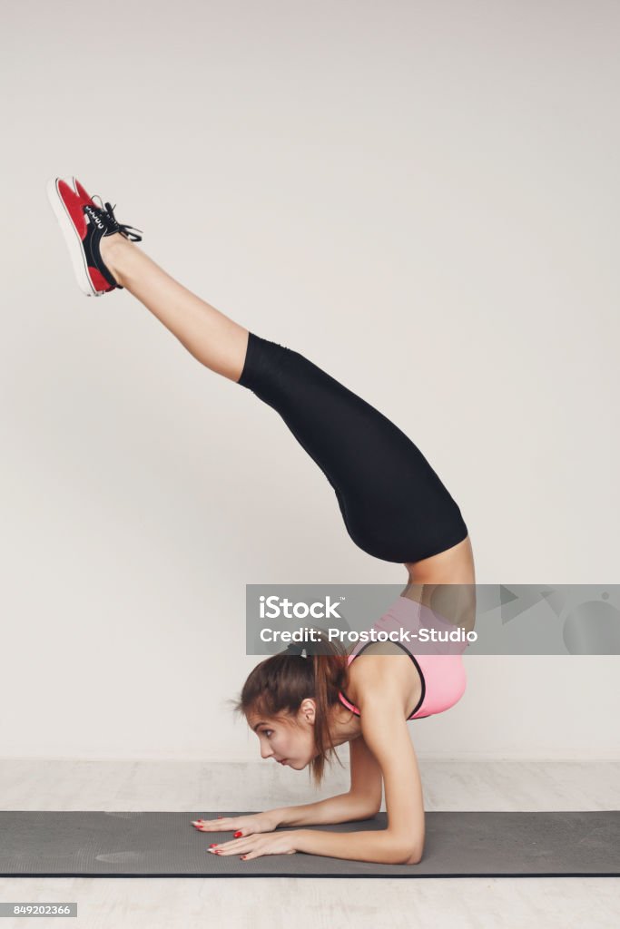 Woman Practicing Yoga Standing In Headstand Pose Stock Photo - Download  Image Now - Adult, Adults Only, Aerobics - iStock