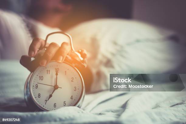 Clock On The Bed In The Morning Stock Photo - Download Image Now - Alarm Clock, Sleeping, Waking up