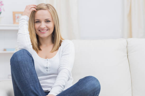 istock Casual happy young woman sitting on sofa 849207502
