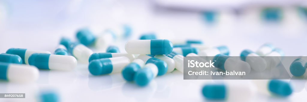 Tablets scattered on the table of the pharmaceutical laboratory Tablets scattered on the table of the pharmaceutical laboratory pill for the prescription and treatment of various diseases chemistry Medicine Stock Photo
