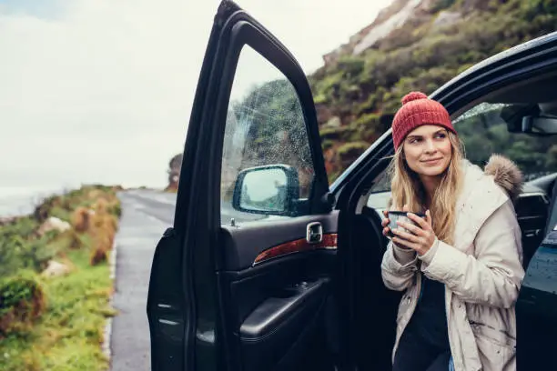 Photo of Woman having coffee during road trip