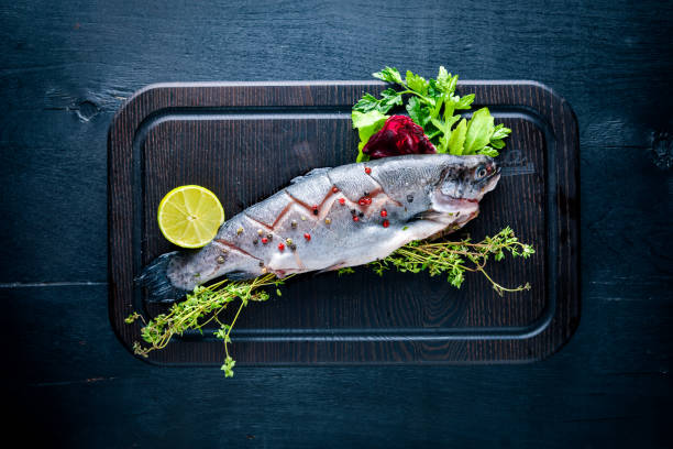 istock Fish trout with aromatic herbs and spices. On Wooden background. 849208400