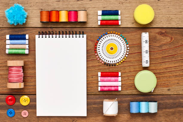istock Overhead view of spiral notebook with sewing items on wood 849211134