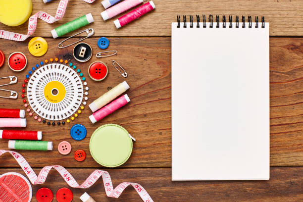 istock Overhead view of spiral notebook by sewing items on table 849211324