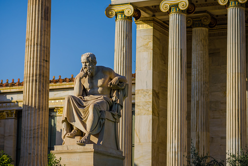 Marble statue of the Greek philosopher Socrates on the background of columns.