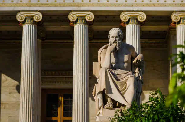 Photo of Marble statue of the Greek philosopher Socrates on the background of classical columns