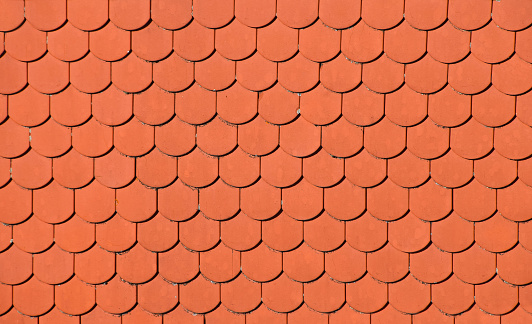 Traditional red brown ceramic roof tiles pattern background, close up, low angle side view