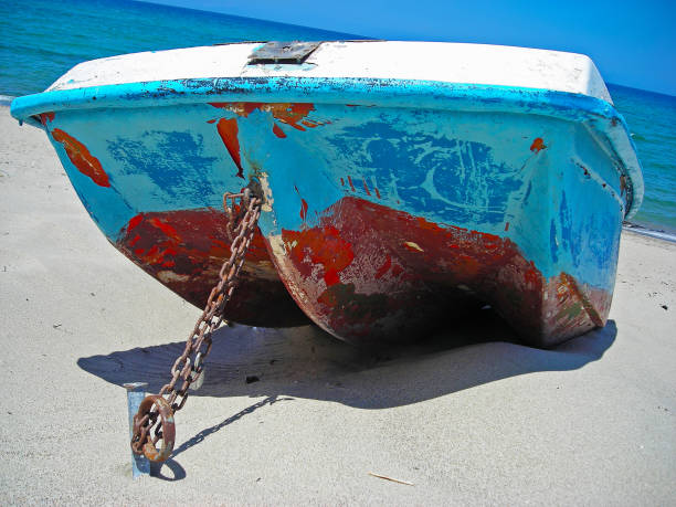 istock boat tied by a metal chain on the sand 849215314