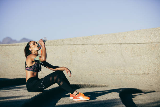mujer sana agua después del ejercicio - healthy eating sport exercising women fotografías e imágenes de stock