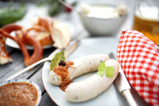 White sausage in a beer garden Beer garden with white sausage and pretzel for a Beer Fest weisswurst photos stock pictures, royalty-free photos & images