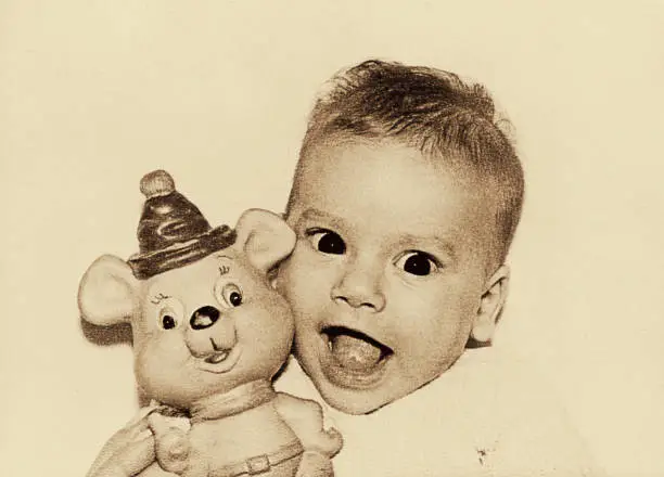 Vintage black and white sepia toned image of a cute baby laughing and looking straight to camera.