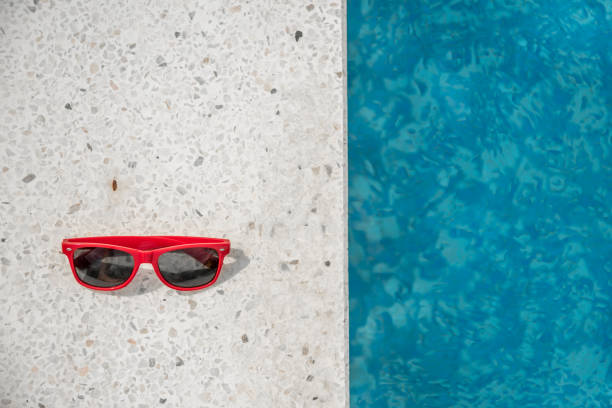 two red sunglasses at swimming pool. copy space - ravena imagens e fotografias de stock